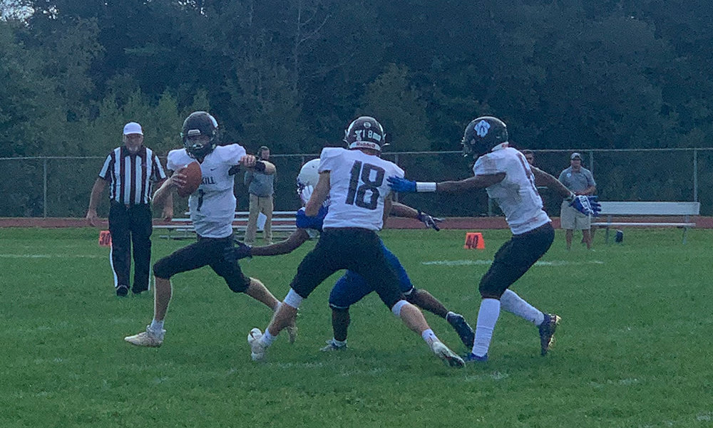Wallkill quarterback Mat Shea gets a good block from wide receiver Jack Rauschenbach as he scrambles for yardage vs. Monticello Saturday.